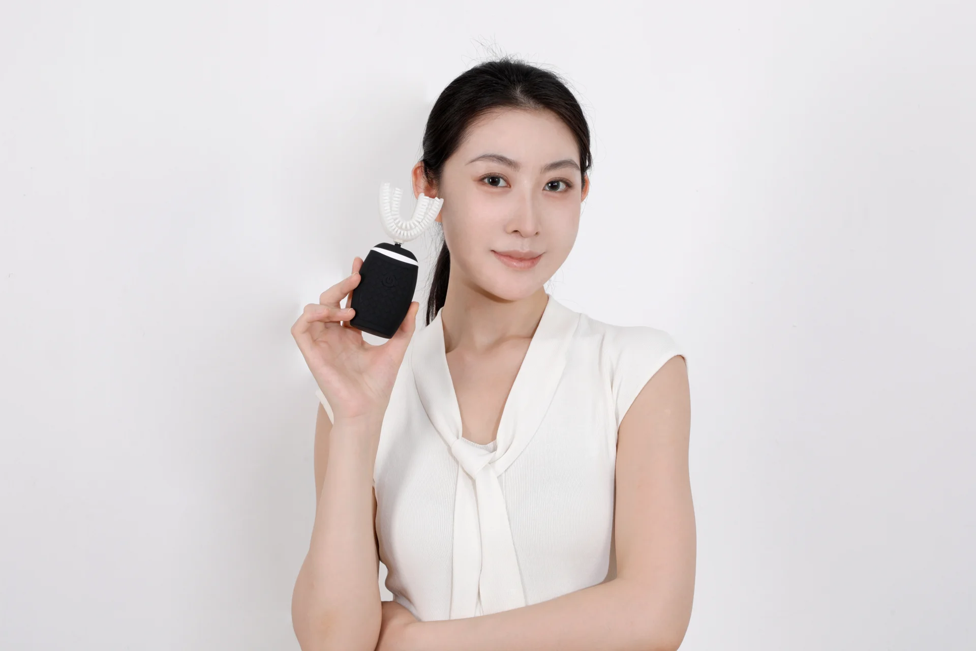 Woman holding a black TB-05 toothbrush